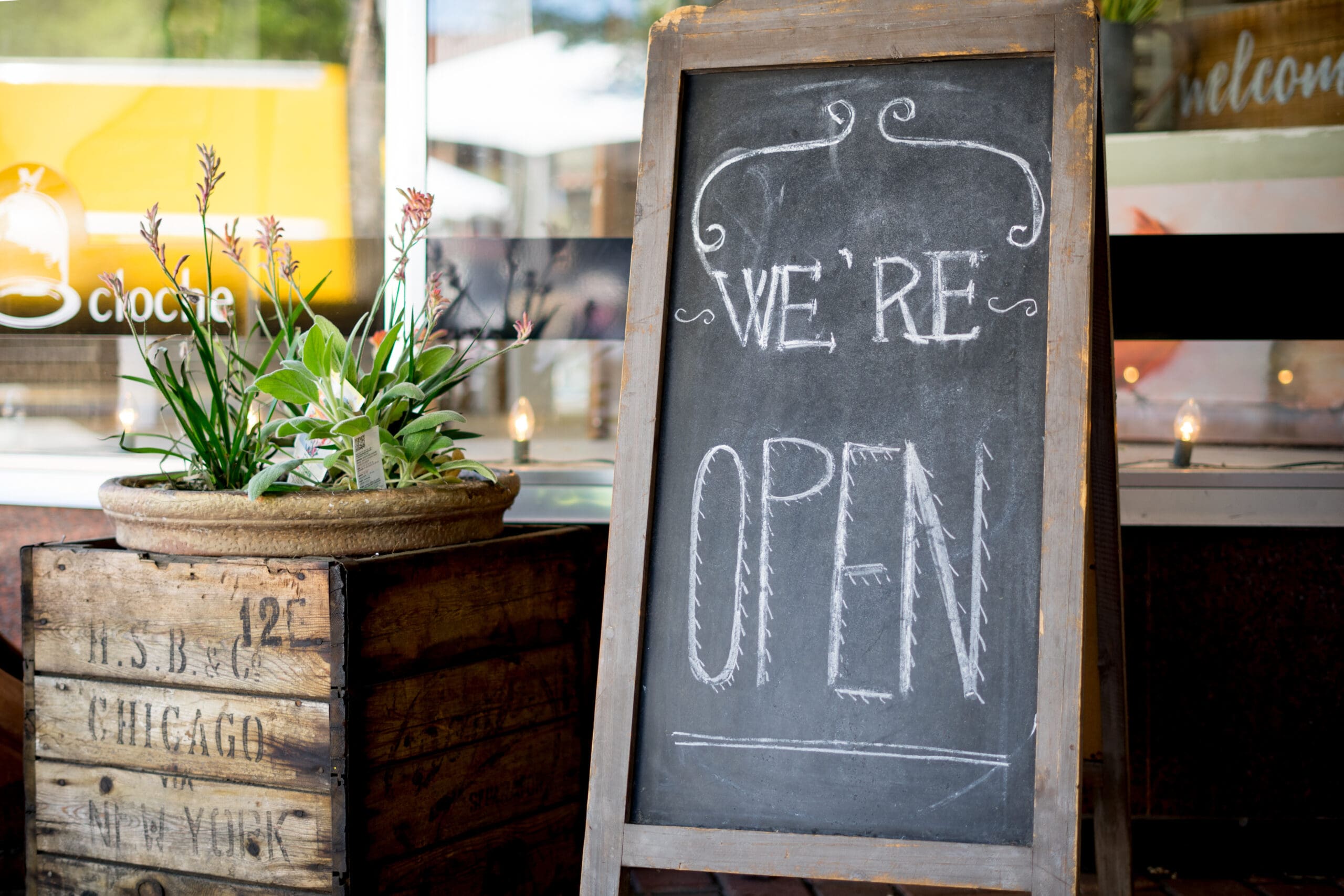 Farmhouse style we're open sign outside small business