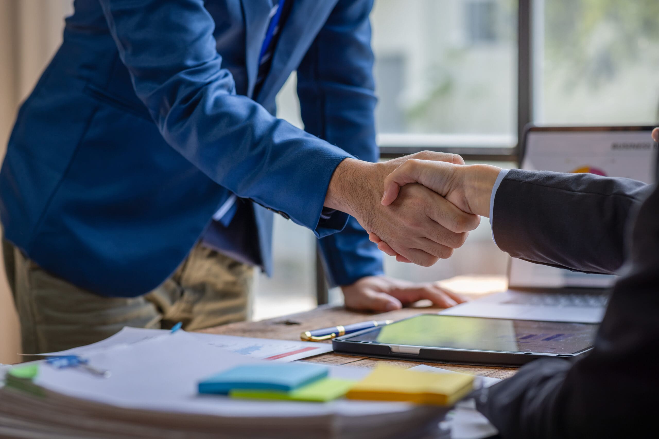 Business handshake over desk